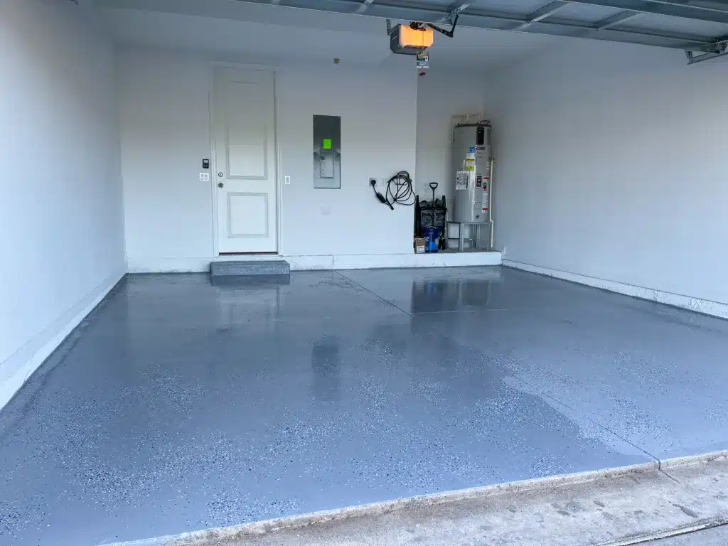 Orlando, FL USA - June 28, 2021: A freshly painted with a gray epoxy finish sprinkled with blue, black and white plastic chips. Install A Garage Floor