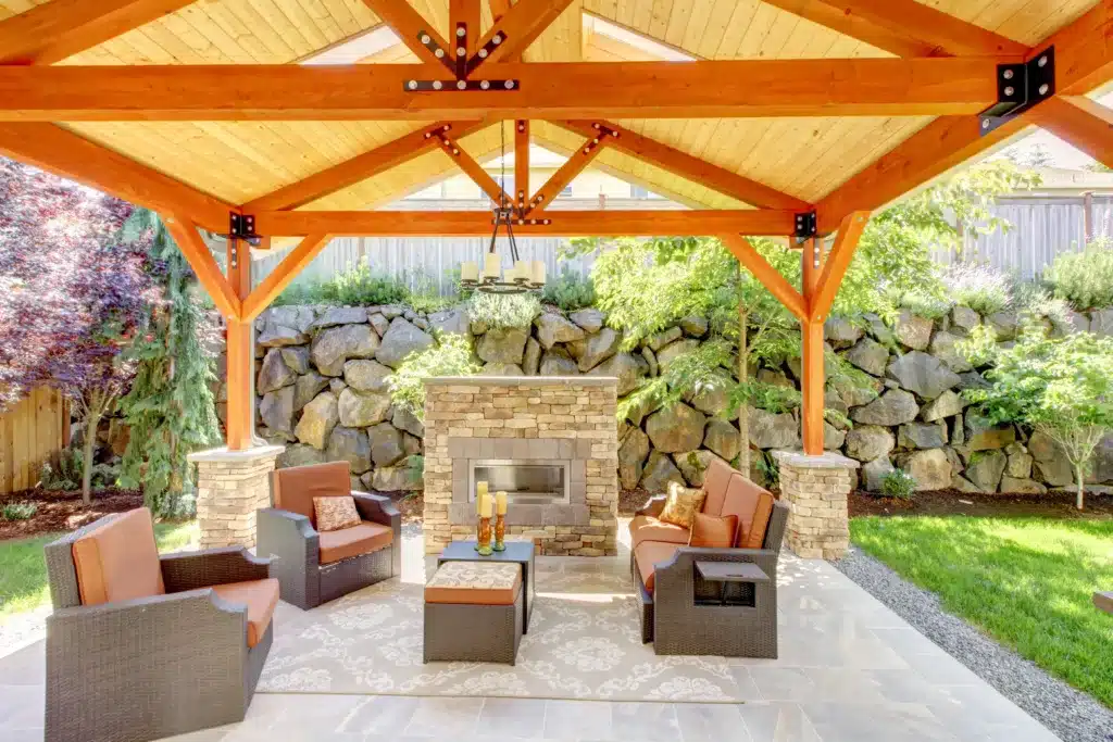 Exterior covered patio with fireplace and furniture. Wood ceiling with skylights. Your Patio in Summer
